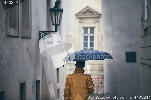 Image of Lonely man with umbrella in rain