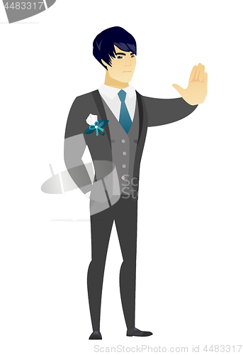 Image of Asian groom showing stop hand gesture.