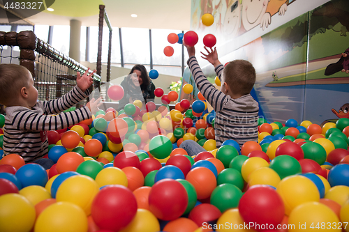 Image of Young mom with her kids in a children\'s playroom