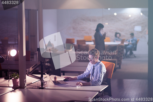 Image of man working on computer in dark office