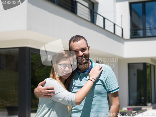 Image of couple hugging in front of  new luxury home