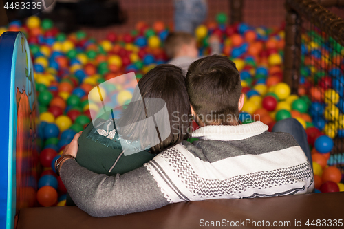 Image of young parents with kids in a children\'s playroom