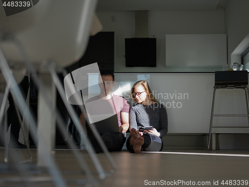 Image of couple using tablet and laptop computers