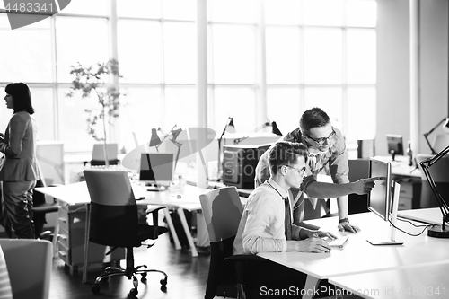 Image of Two Business People Working With computer in office