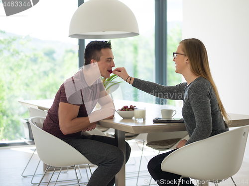 Image of couple enjoying morning coffee and strawberries