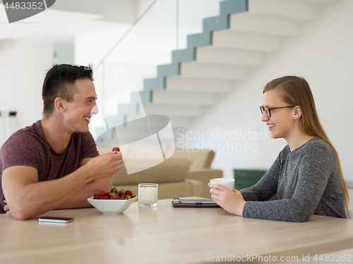 Image of couple enjoying morning coffee and strawberries