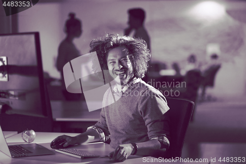 Image of man working on computer in dark office