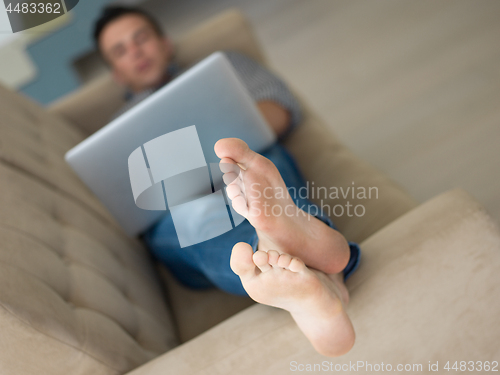 Image of Man using laptop in living room