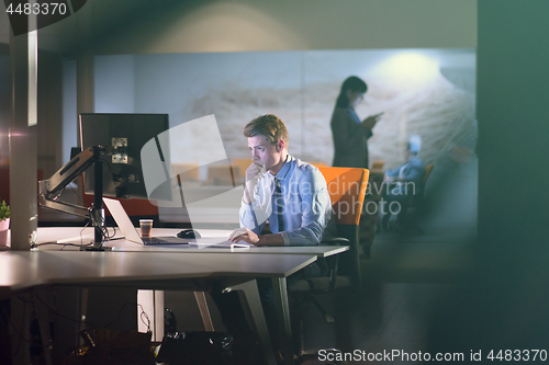 Image of man working on computer in dark office