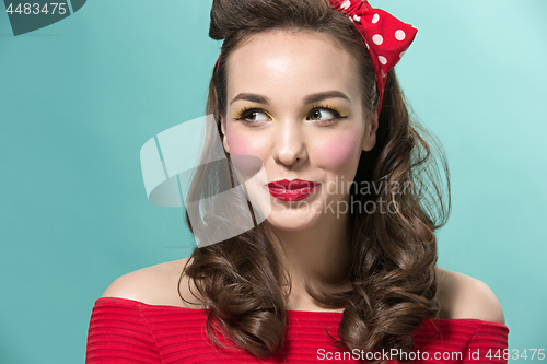 Image of Beautiful young woman with pinup make-up and hairstyle. Studio shot on white background