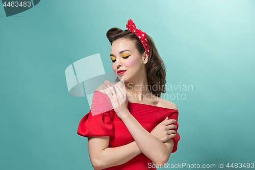 Image of Beautiful young woman with pinup make-up and hairstyle. Studio shot on white background