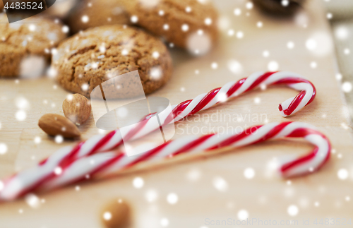 Image of candy canes, cookies and almonds on board