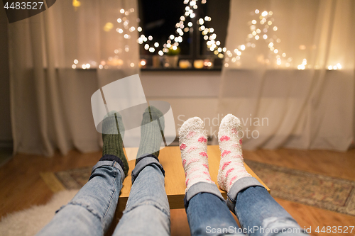 Image of close up of couple feet and garland lights at home