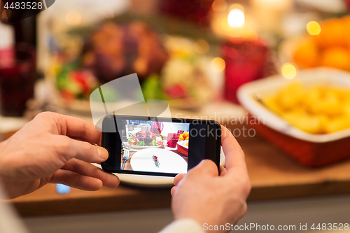 Image of hands photographing food at christmas dinner