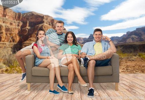 Image of friends sitting on sofa over grand canyon