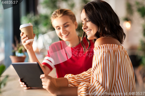 Image of female friends with tablet pc and coffee at cafe