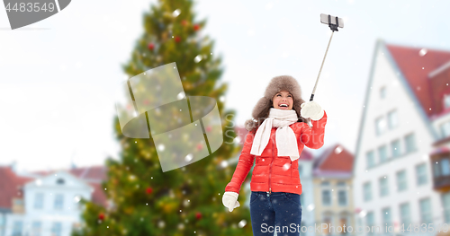 Image of woman taking selfie over christmas tree