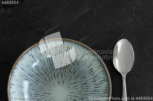 Image of close up of ceramic plate and spoon on table