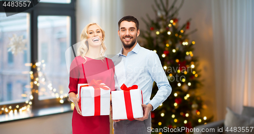 Image of happy couple with christmas gifts at home