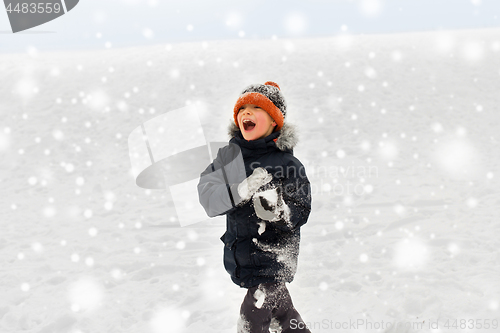 Image of happy little boy playing with snow in winter