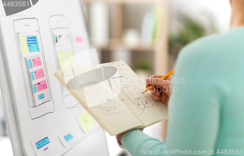Image of ui designer with user interface sketch in notebook
