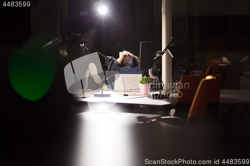 Image of businessman sitting with legs on desk at office