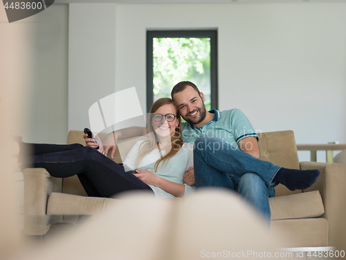 Image of Young couple on the sofa watching television