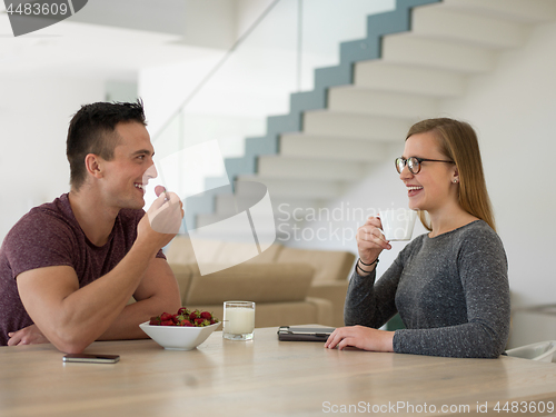 Image of couple enjoying morning coffee and strawberries