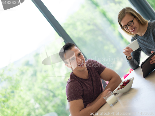 Image of couple enjoying morning coffee and strawberries