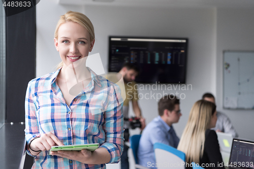 Image of Pretty Businesswoman Using Tablet In Office Building by window