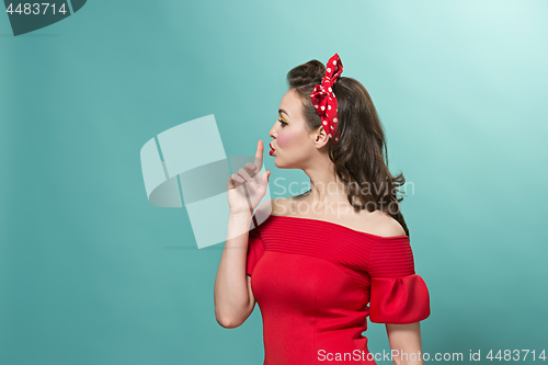 Image of Beautiful young woman with pinup make-up and hairstyle. Studio shot on white background