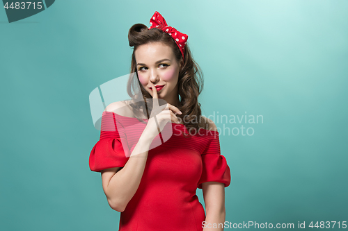 Image of Beautiful young woman with pinup make-up and hairstyle. Studio shot on white background