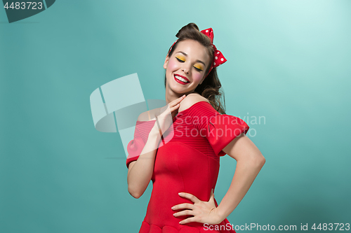 Image of Beautiful young woman with pinup make-up and hairstyle. Studio shot on white background