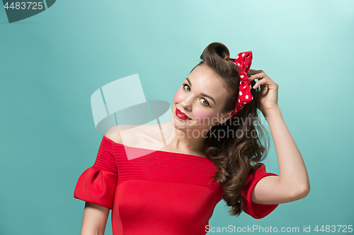 Image of Beautiful young woman with pinup make-up and hairstyle. Studio shot on white background