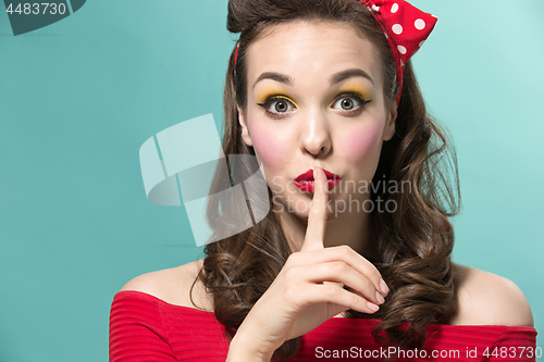 Image of Beautiful young woman with pinup make-up and hairstyle. Studio shot on white background