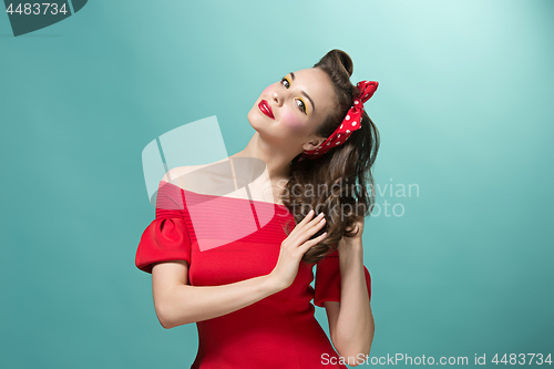 Image of Beautiful young woman with pinup make-up and hairstyle. Studio shot on white background