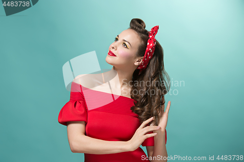 Image of Beautiful young woman with pinup make-up and hairstyle. Studio shot on white background