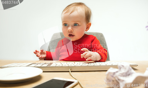 Image of Happy child baby girl toddler sitting with keyboard of computer isolated on a white background
