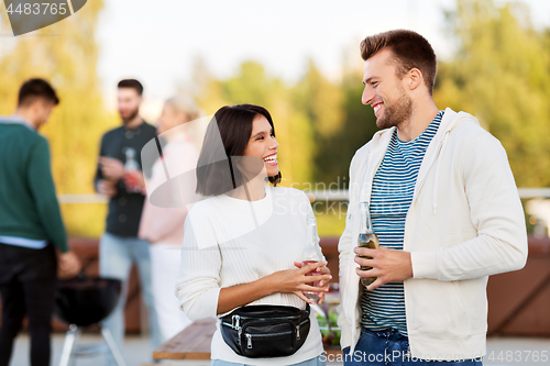 Image of happy couple with drinks at rooftop party