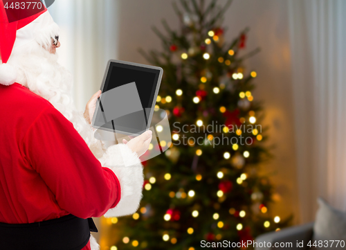 Image of santa claus with tablet pc over christmas tree