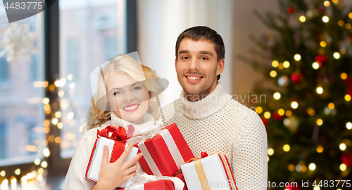 Image of happy couple with christmas gifts at home