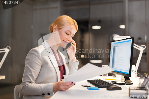 Image of businesswoman calling on smartphone at office