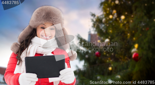 Image of woman with tablet pc over christmas tree