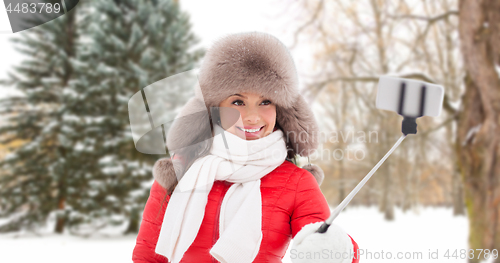 Image of happy woman taking selfie over winter forest