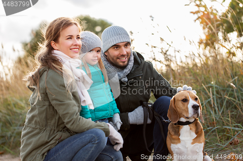 Image of happy family with beagle dog outdoors in autumn