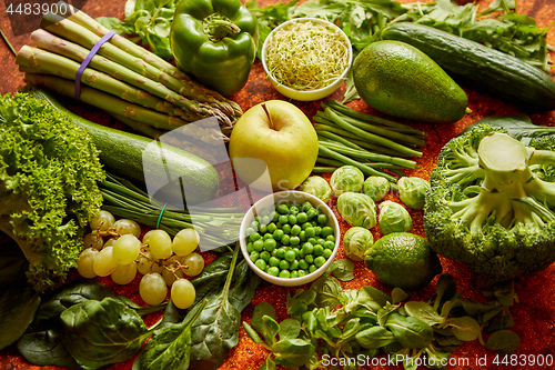 Image of Fresh green vegetables and fruits assortment placed on a rusty metal