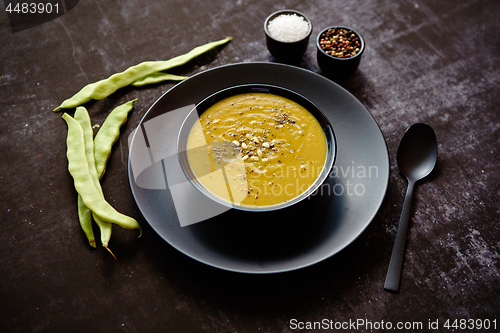 Image of Creamy soup with green pea in a ceramic white plate