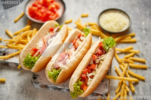 Image of Assortment of three tasety hot dogs, placed on wooden cutting board