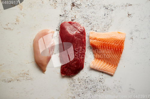 Image of Fresh raw beef steak, chicken breast, and salmon fillet