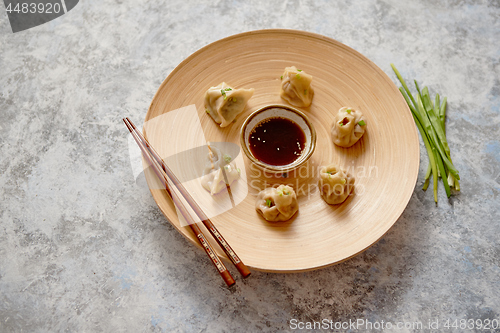 Image of Delicious chinese dumplings served on wooden plate